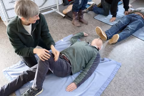 First Aid trainees practising placing a casualty into the "recovery position"